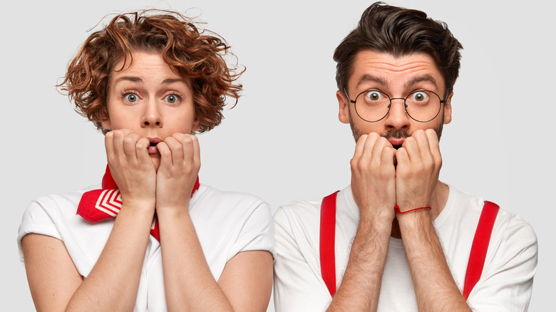 Man and woman biting their nails