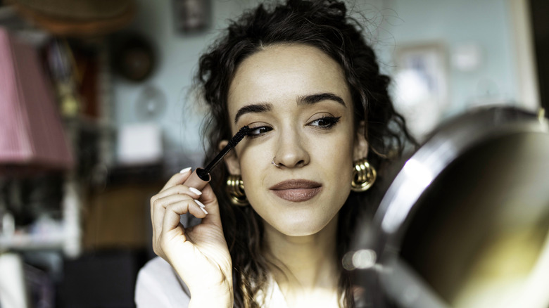 A woman applying mascara
