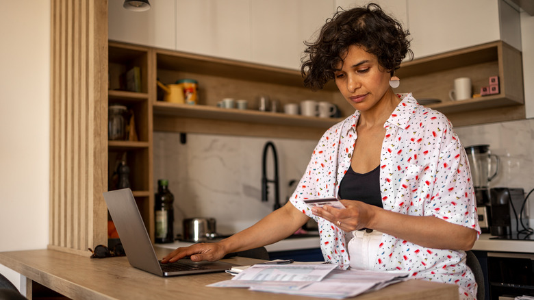 Woman paying bills in kitchen