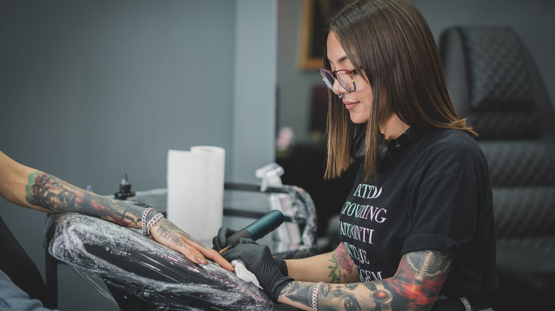 woman tattooing finger