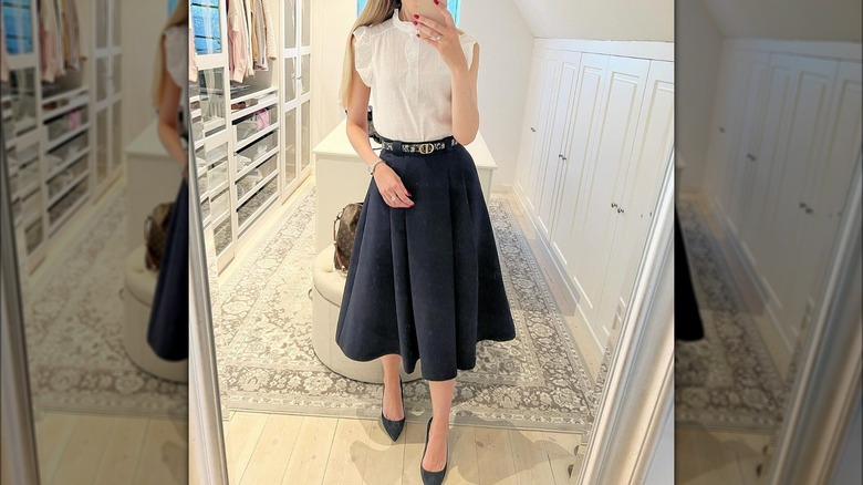 Person in navy blue skirt and white blouse