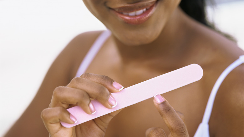 woman filing fingernails
