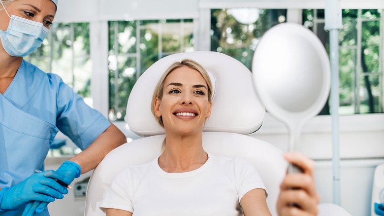Woman looking at lips in mirror
