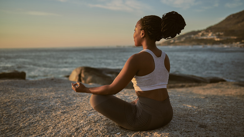 person meditating on beach