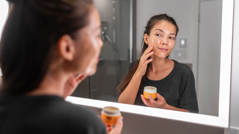 Woman putting acne treatment on face
