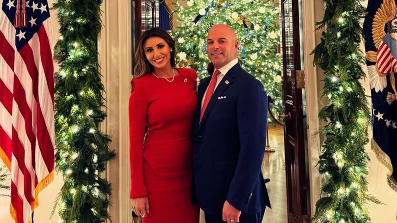 Alina Habba and Gregg Reuben taking a photo together in the White House surrounded by Christmas decorations