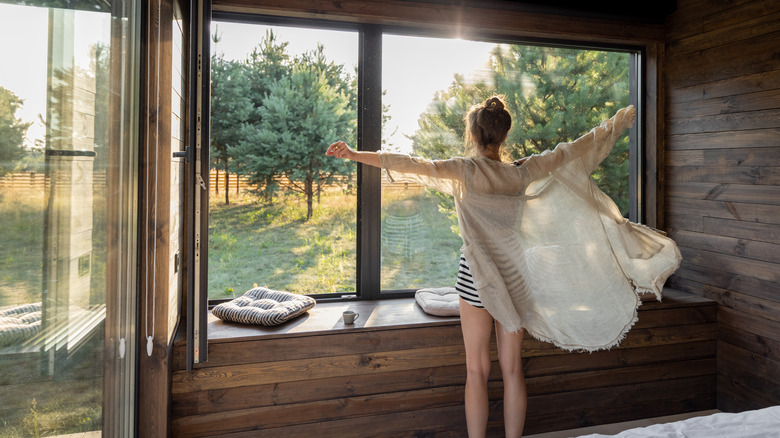 woman waking up at sunrise 