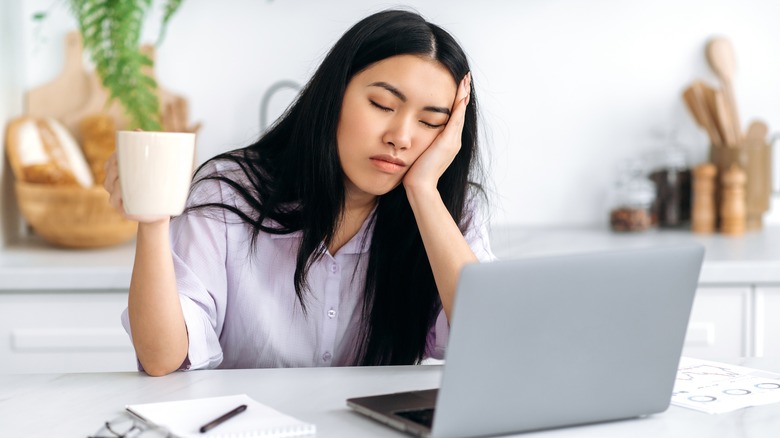 woman falling asleep near laptop