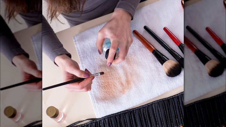 Woman spraying makeup brush