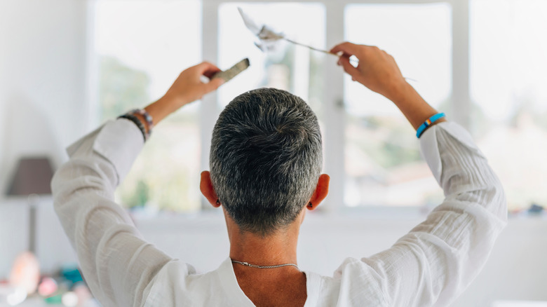 Woman burning sage in a house.