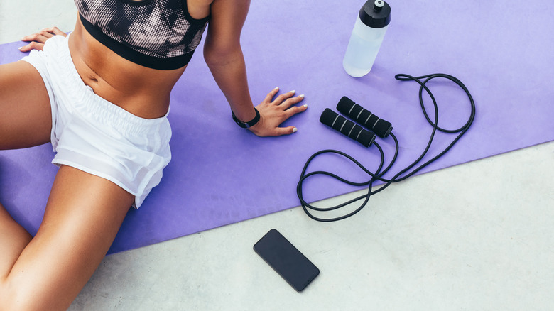 woman sitting on workout mat