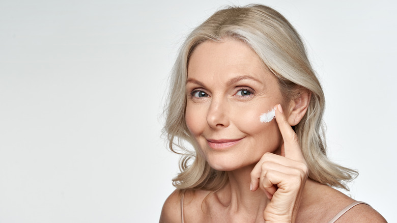 mature woman applying face cream