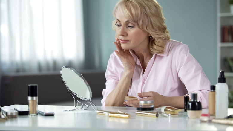 mature woman applying foundation
