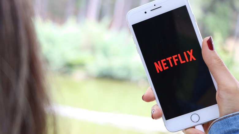 woman watching Netflix on iPhone