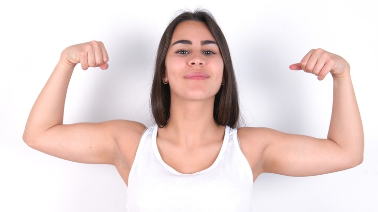 Girl in tank flexing arms