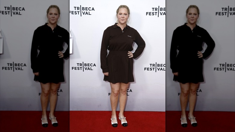Amy Schumer in a black shirt and skirt