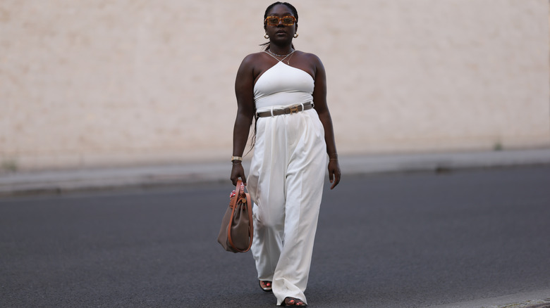 woman wearing a white halter top and linen trousers