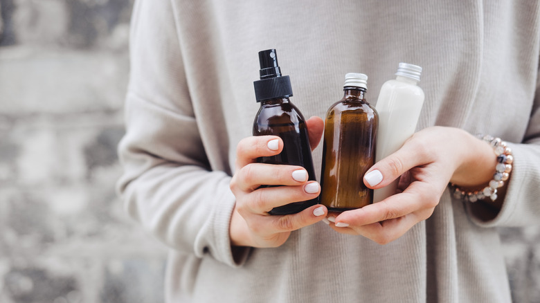 woman holding skincare bottles 