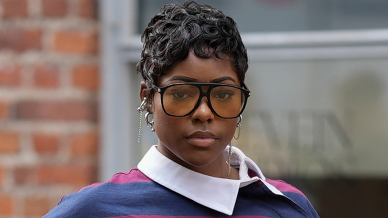 A woman with a curly pixie and multiple earrings