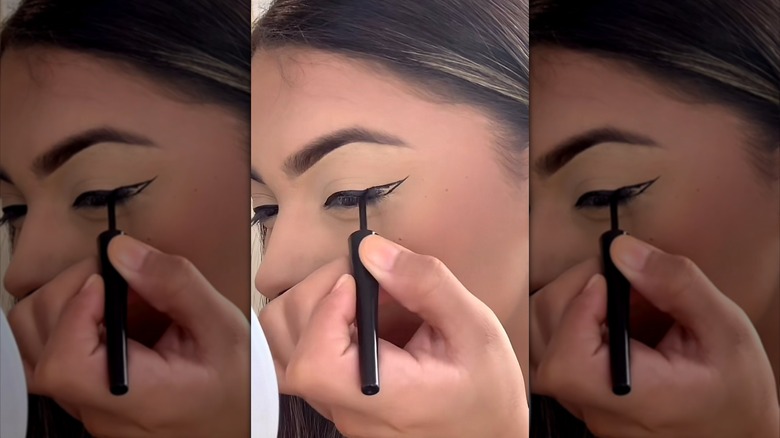woman creating angel wing eyeliner