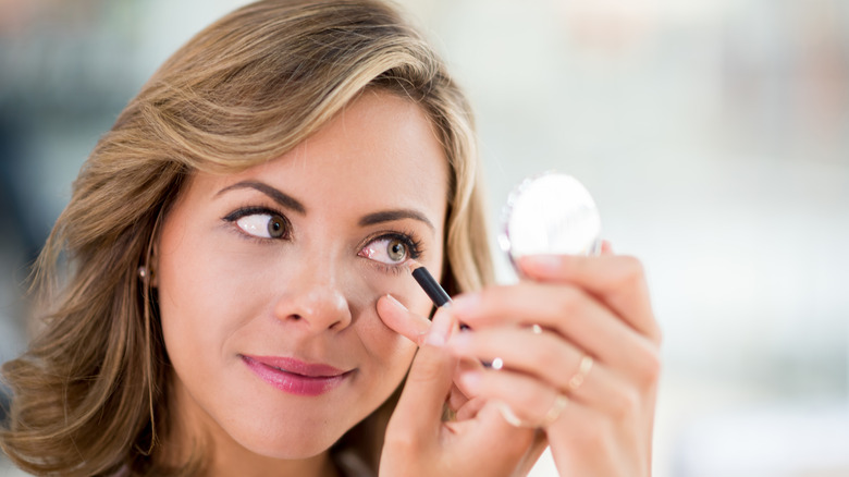 woman applying eyeliner