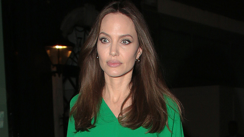 Angelina Jolie with curly blond hair and red lipstick.