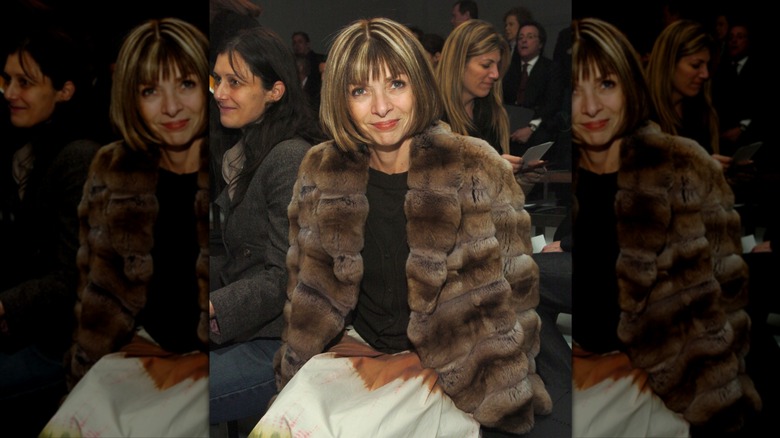 Anna Wintour smiles with chunky blonde highlights wearing a brown fur coat