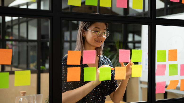 Woman putting sticky notes on widows