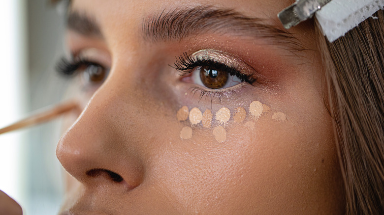 Girl applying concealer