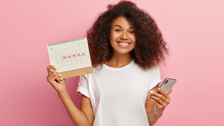 woman holding up period calendar