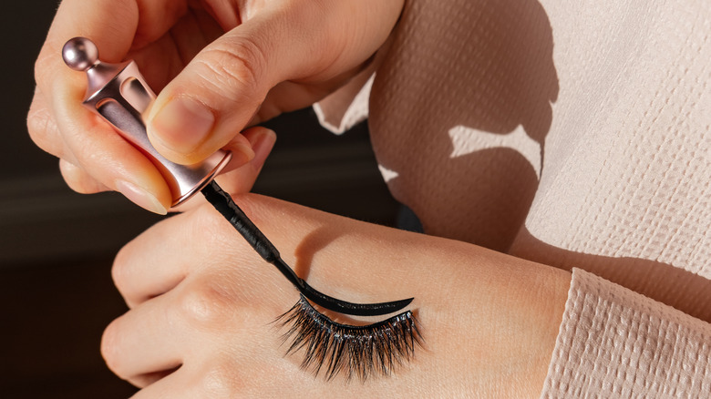 woman applying magnetic eyeliner on back of hand