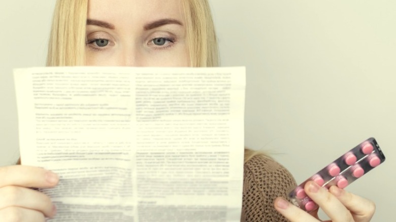 woman reading pill instructions