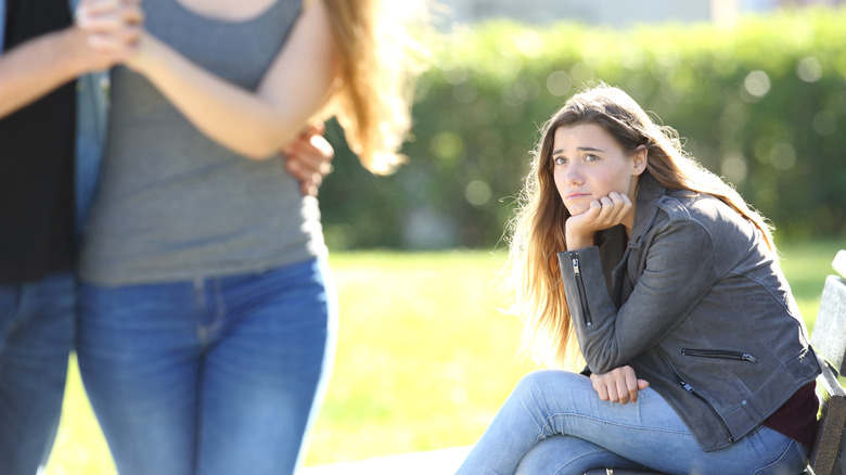 woman on bench watching couple
