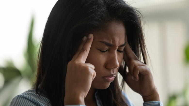 Woman with fingers to head