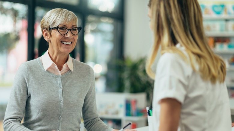 Two people talking at store counter