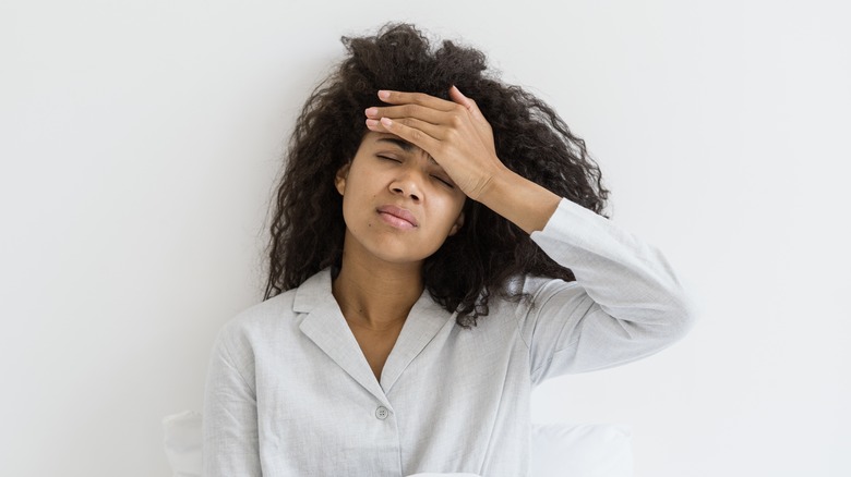 woman holding head headache