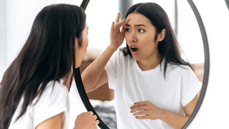 surprised woman discovering wrinkles