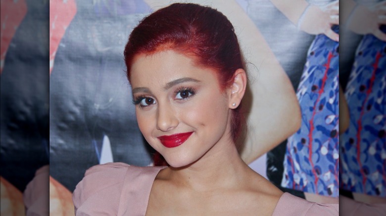 Ariana Grande posing with red dye on her scalp from her red hair