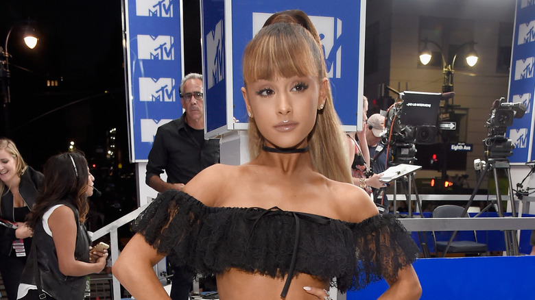 Ariana Grande posing in a black two-piece