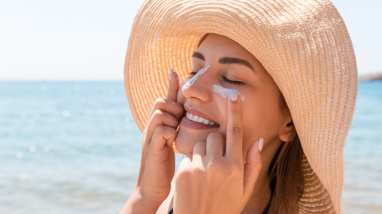 woman applying sun block under the eyes