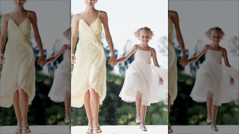 woman wearing a yellow dress and holding a child's hand