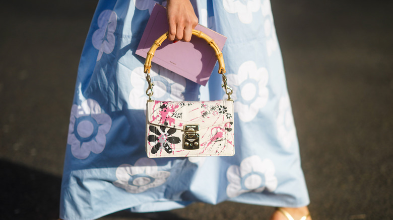 woman holding bag with bamboo handle