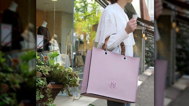 model with straw bag and bamboo handles