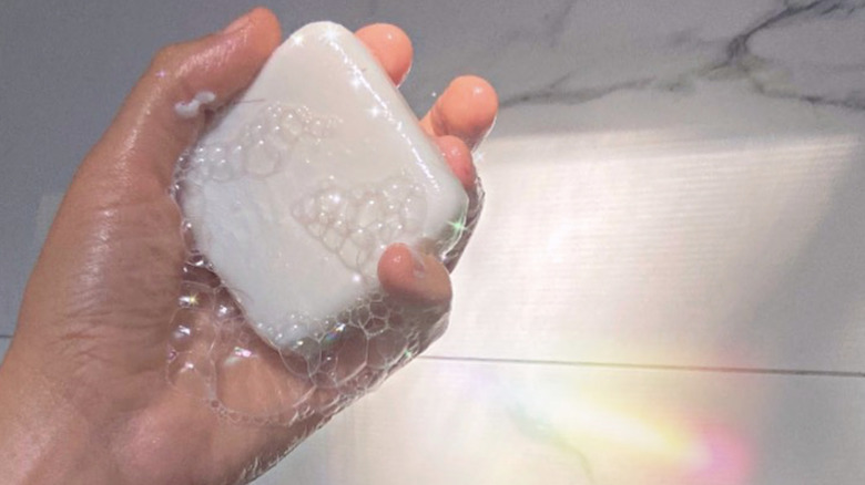 person holding wet shampoo bar