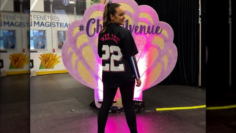 Woman wearing a baseball jersey over a long-sleeved shirt