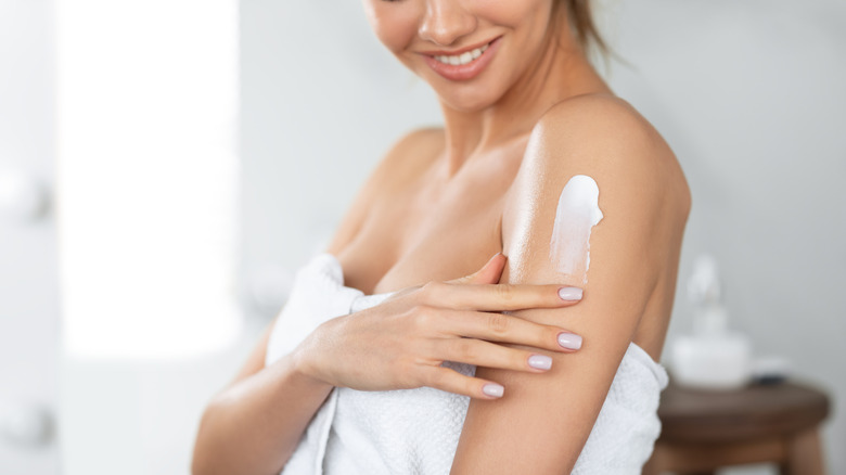 woman applying lotion to arm