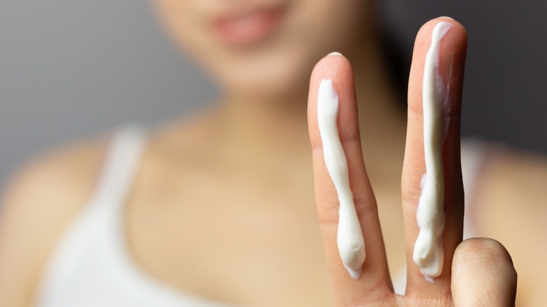 two fingers with sunscreen streaks