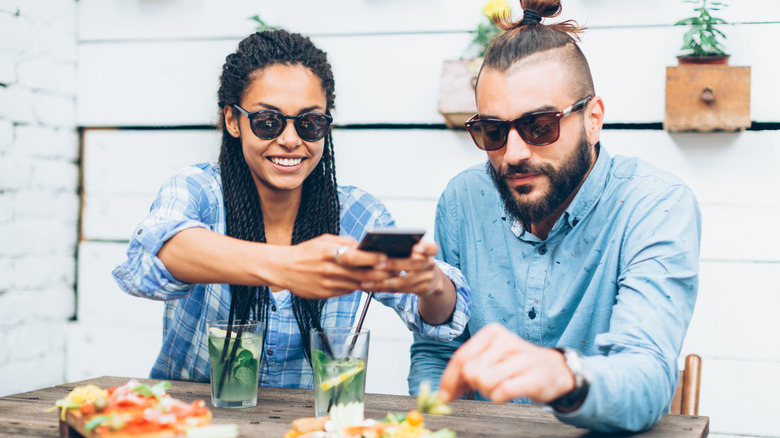 woman taking photo of meal
