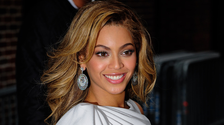 Beyoncé in a white dress posing for a photo