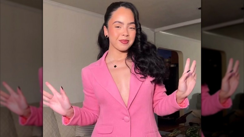 Jenny Delarosa with big curls and pink suit